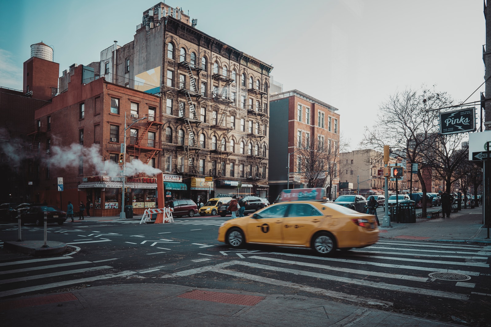 yellow taxi cab on road near building during daytime